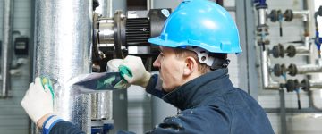 industrial construction worker at boiler room pipe heat insulation work